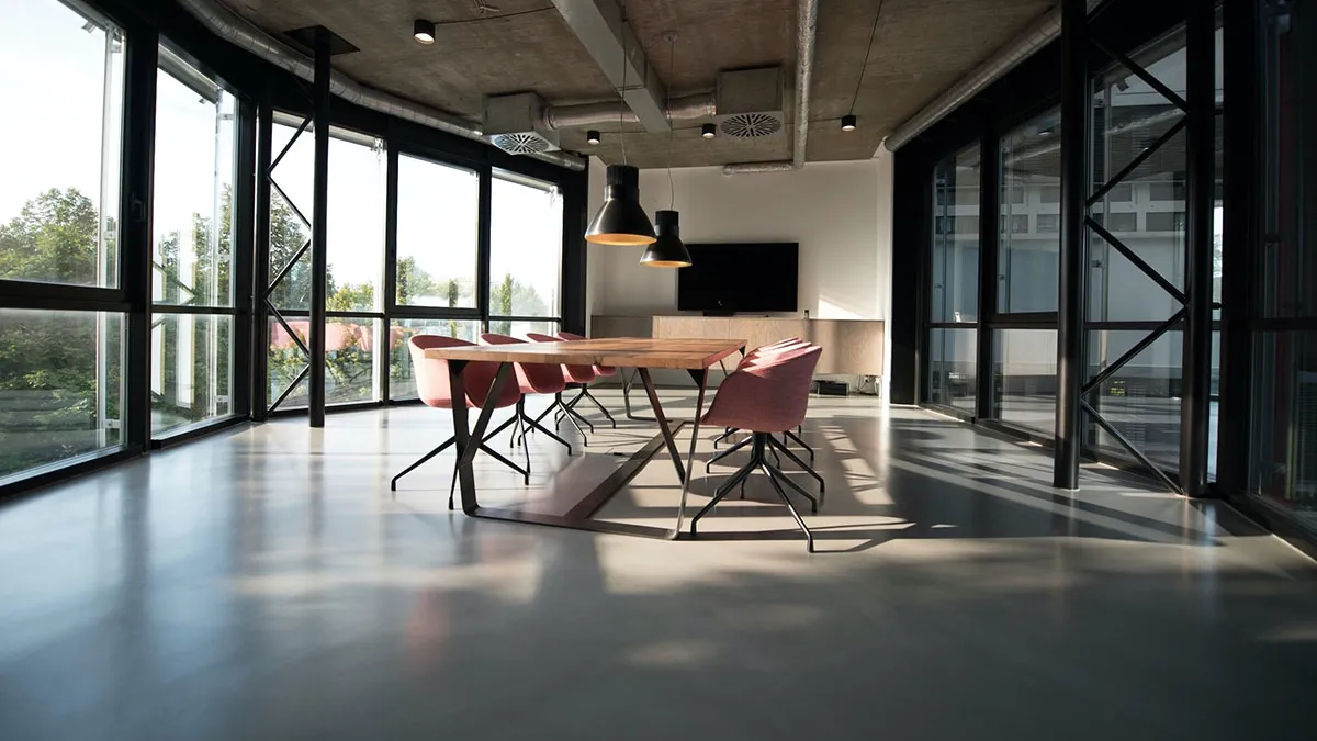 A bright coworking space with a long shared table, ready for a tour