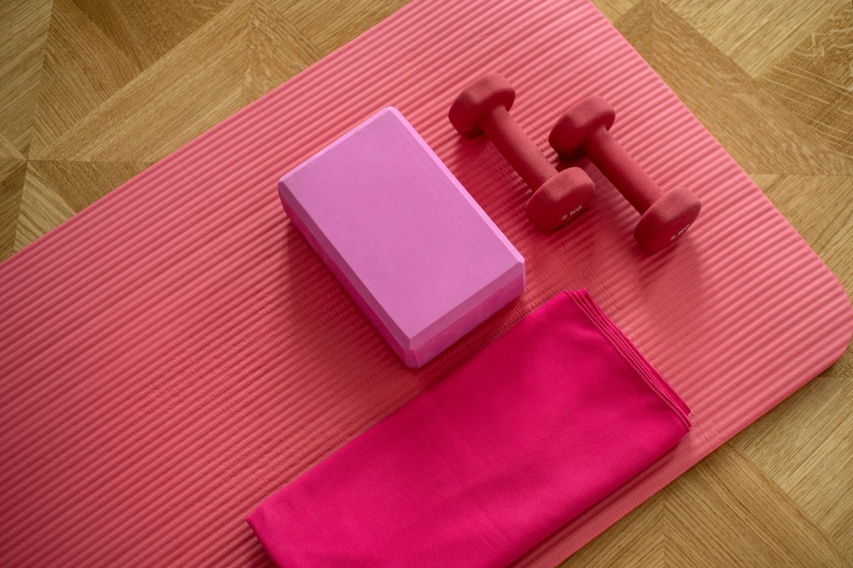 Light dumbbells and a foam block on an exercise mat