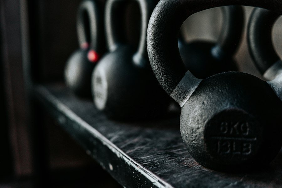 Black kettlebells on a rack in low light