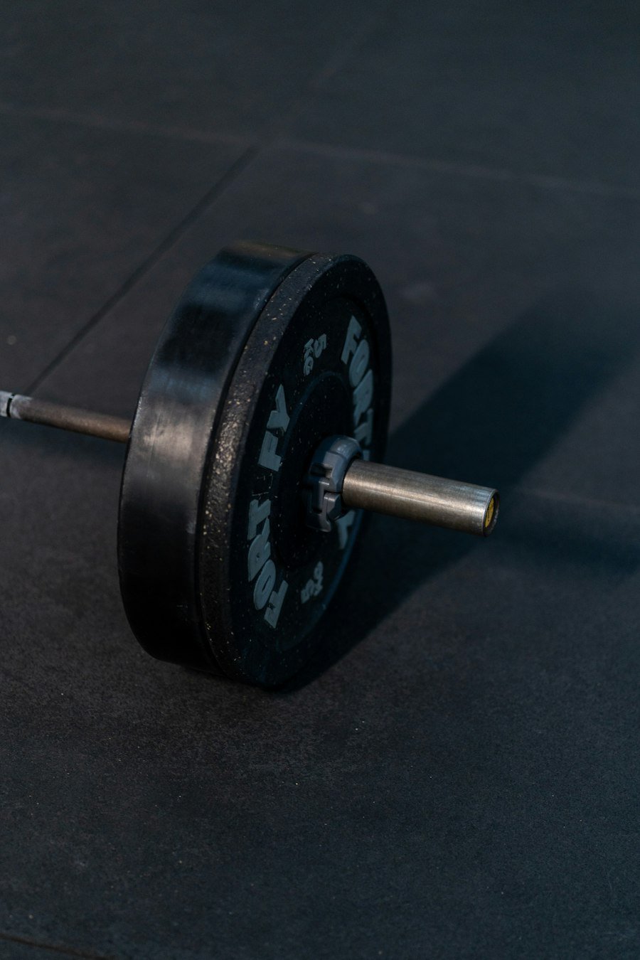 Close-up of a weight plate on a barbell resting on a gym floor